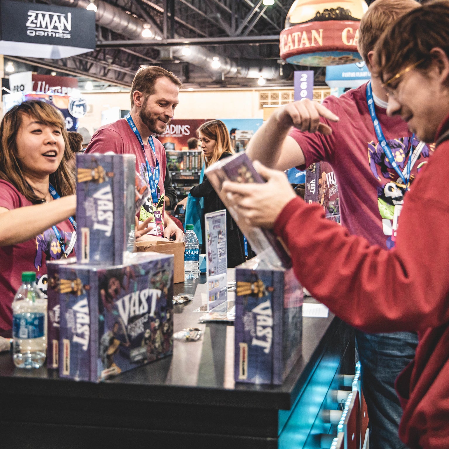 Leder Games employees selling Vast: The Mysterious Manor at a convention