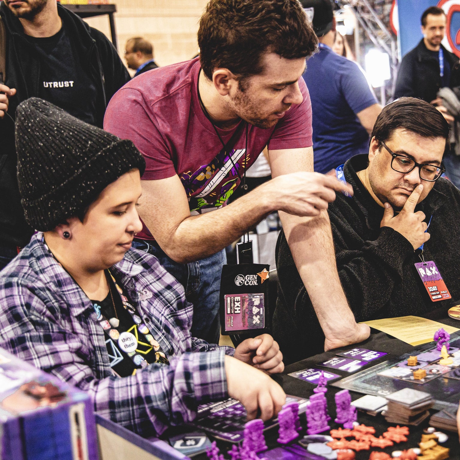 Leder Games employee overseeing a game demo of Vast: The Mysterious Manor at a convention