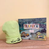 Our adorable Lizard Cult embroidered beanie next to the Root Riverfolk Expansion box.
