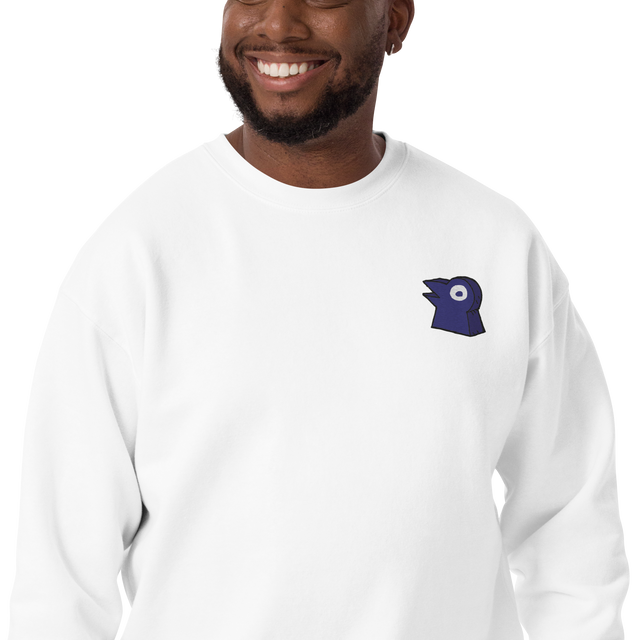 A model wearing a white crewneck with the Corvid Conspiracy meeple embroidered on the left chest.
