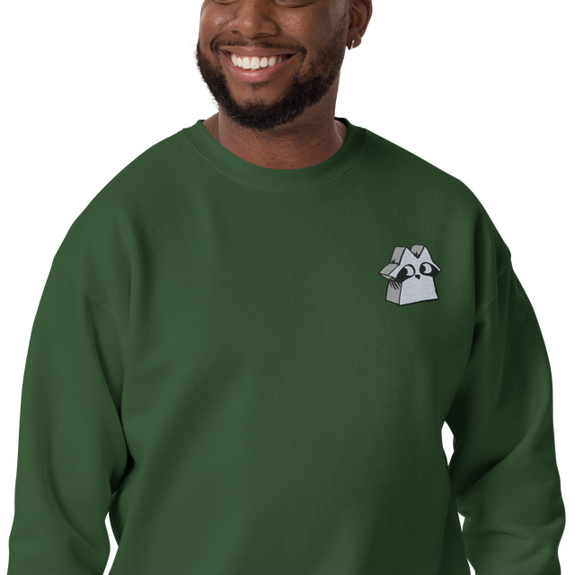 A model wearing a Green crewneck sweatshirt with the Raccoon Vagabond meeple embroidered on the left chest.