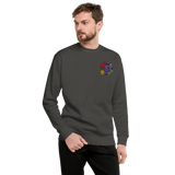 A model wearing a slate grey crewneck sweatshirt with the Vast: The Mysterious Manor characters embroidered on the left chest.