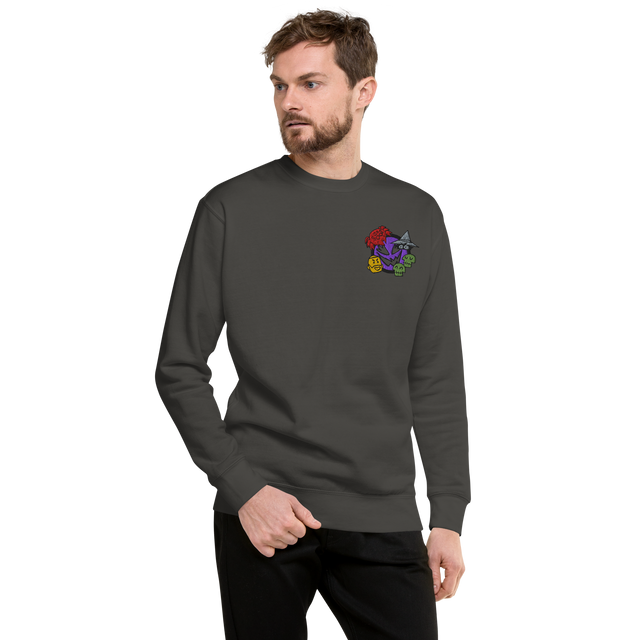 A model wearing a slate grey crewneck sweatshirt with the Vast: The Mysterious Manor characters embroidered on the left chest.