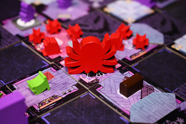 The red giant wooden spider meeple in play on the Mysterious Manor game board